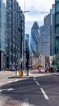 Long exposure time lapse of the traffic in the City of London around Bishopsgate and Liverpool Street with car and pedestrian traffic in front of the skyline
