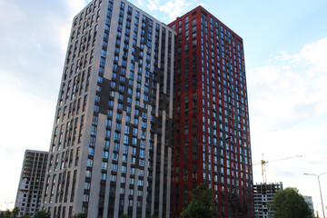 Fototapeta premium a modern beautiful residential building with a red facade against a clear blue sky 