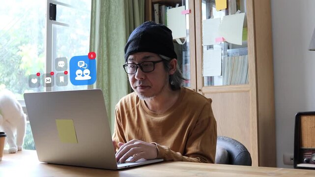 Mature East Asian man with white hair in casual wear using laptop at home office, with 3D tracked social profile badges, heart likes, and chat bubbles.