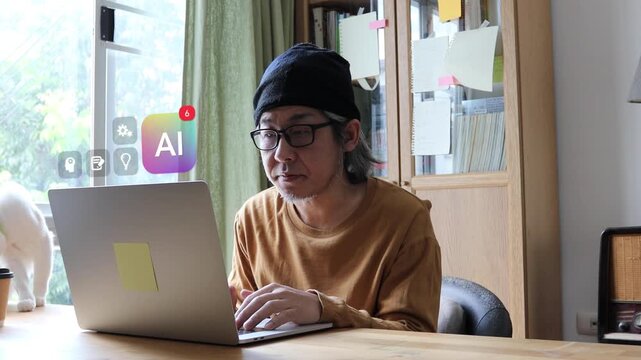 Mature East Asian businessman working on laptop at home, showing 3D tracked virtual artificial intelligence badge, brain gear, and pen note icons popping up.