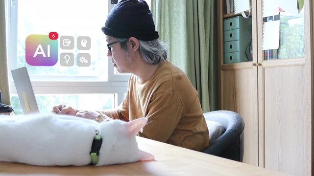 Mature East Asian man with glasses using laptop at home office with white cat by his side, featuring a 3D tracked virtual AI badge and floating brain gear pop ups.