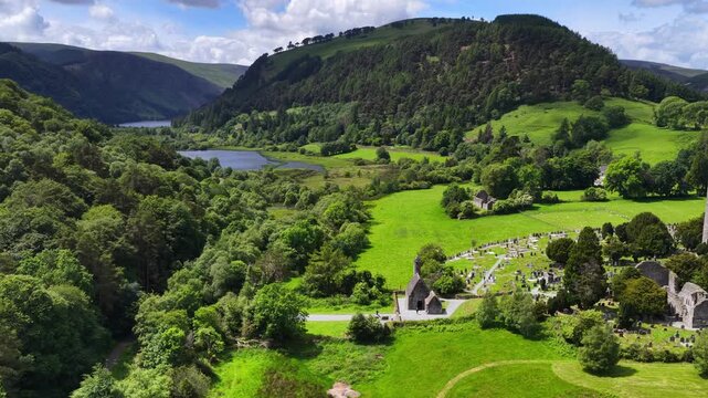 drone shot of Glendalough valley in Ireland, hiking and tourism in Ireland, Wicklow mountains with historic village and scenic lake, ruins of medieval tower and church in Glendalough