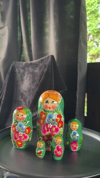 Nested Dolls Display: A set of beautifully handcrafted Matryoshka dolls, each intricately painted with vibrant floral patterns, are displayed in a charming arrangement.
