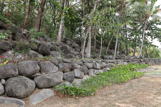 boulder retaining wall stabilizing sloped area, large, stacked rocks, small plantings, trees growing on upper terrace (wide-angle, landscape, rain-forest, tropical) 4069