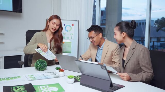 Group of Asian business professionals in a modern office meeting, discussing sustainable strategies and corporate social responsibility goals related to ESG principles for a greener company future