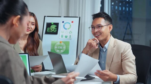 Businesspeople having a productive discussion about environmental, social, and governance principles in a modern office meeting room, focusing on sustainable corporate strategy at night