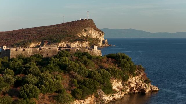 Aerial view of Porto Palermo Castle on a rocky peninsula surrounded by the blue waters of the Ionian Sea in Porto Palermo, Qarku i Vlores, Albania.