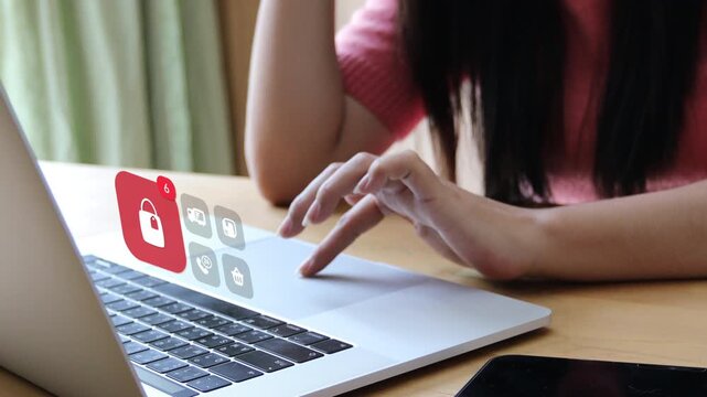 Adult Asian woman typing on laptop keyboard, displaying a 3D tracked retail shopping bag notification badge with floating parcel truck and cart pop up icons.