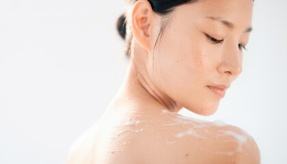 Naklejka premium Beautiful Asian woman with clean skin looking down 美しい肌の女性の横顔