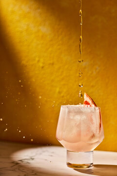 Elegant Cocktail Splash With Citrus Garnish in Golden Light 
