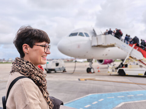 Young woman smiling boarding airplane at Bucharest airport