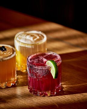 Colorful Craft Cocktails with Citrus Garnish in Warm Moody Lighting. 