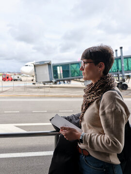 Woman traveling at Bucharest airport holding boarding pass