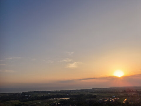 Beautiful golden sunset over a vast coastal landscape and rural fields under a wide clear sky