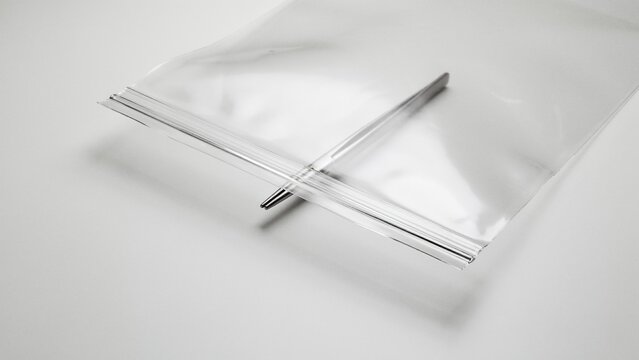Tweezers rest inside a clear plastic resealable bag lying flat on a bright surface with plenty of empty copy space.