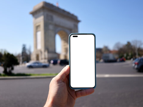 Hand holding smartphone with blank screen in Bucharest