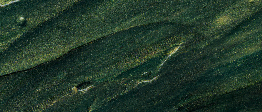 Abstract dark green oil paint texture with golden shimmer and diagonal brushstrokes on canvas