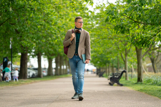 Man walking along tree-lined path in Greenwich Park London