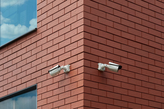 Security cameras on red brick building wall