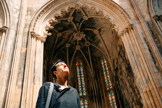 Person Looks up at Stained Glass Ceiling in Historic Building