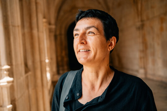 Person Smiles Inside Historic Building in Warm Sunlight During Day
