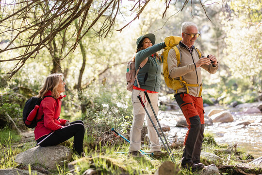Senior friends enjoying nature hiking and helping each other