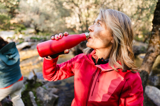 Senior woman drinking water from bottle outdoors