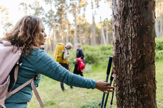Mature woman hiking in forest connecting with nature