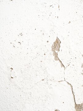 White distressed plaster wall texture with cracks, peeling paint, and subtle stains; minimal grunge background for design, renovation, or vintage concepts.