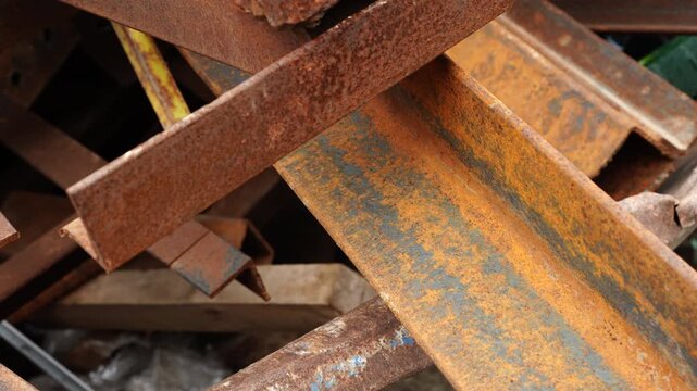 Rusty steel beams and construction scrap metal pile from demolition or construction site