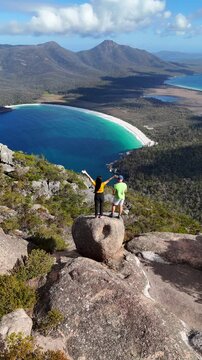 Vertical aerial drone view of Tasmania Island. Wineglass Bay hike, Freycinet National Park. People enjoying the beautiful view after a strenuous hike. Tasmania, Australia. 