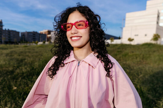 Woman smiling wearing pink sunglasses