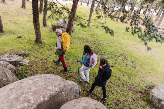 Multi generational family hiking together with trekking poles