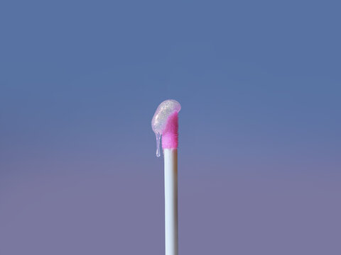 Lip gloss applicator with a drop of shimmering gloss