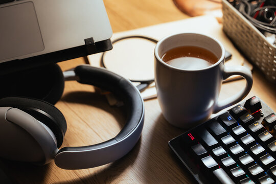 Gamer Headphones and Coffee Mug on Desk with RGB Keyboard
