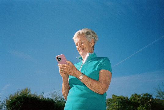 Senior woman texting cell phone outdoors film