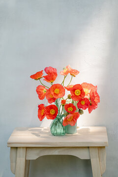 Three vases of poppies on a table