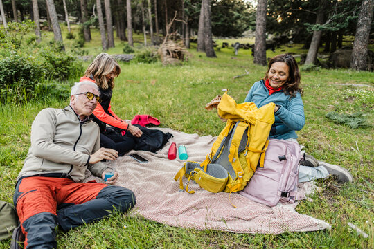 Friends enjoying break during outdoor adventure in forest