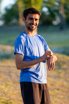 Young man smiling checking fitness tracker on wrist