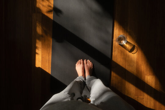 POV standing on yoga mat in sunlight at home