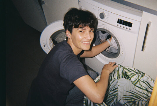 Happy person doing laundry day chores at home