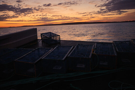 Lobster traps await dropoff at sunset near the water