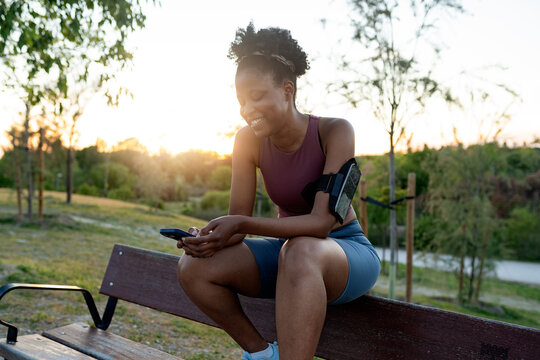 Woman relaxing with phone after running workout
