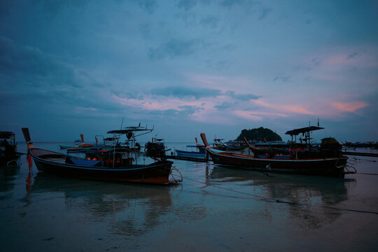 Long tail boat anchored near shore on a calm day on a Thai island