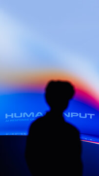 Human silhouette observes screen in a tech setting