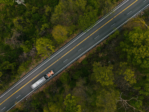Aerial View of Truck Driving Through Forest Road