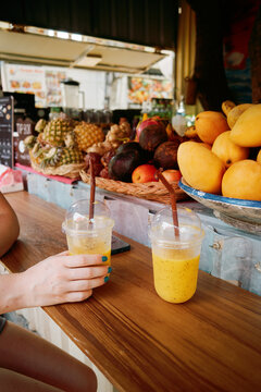Enjoying fresh mango smoothies at a local market in the afternoon