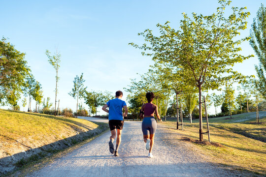 Couple running on park path during training session