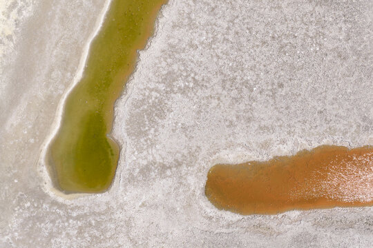 Crusty salt deposits around the edges of colorful salt lakes 