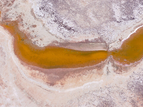 Crusty salt deposits around the edges of colorful salt lakes 